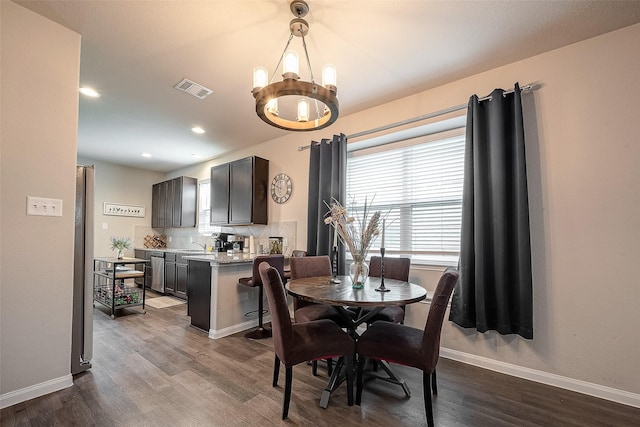 dining room featuring sink, a chandelier, and wood-type flooring