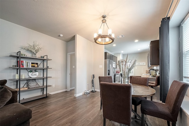 dining space featuring dark hardwood / wood-style flooring and a notable chandelier