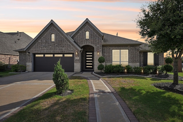 view of front of property with a yard and a garage