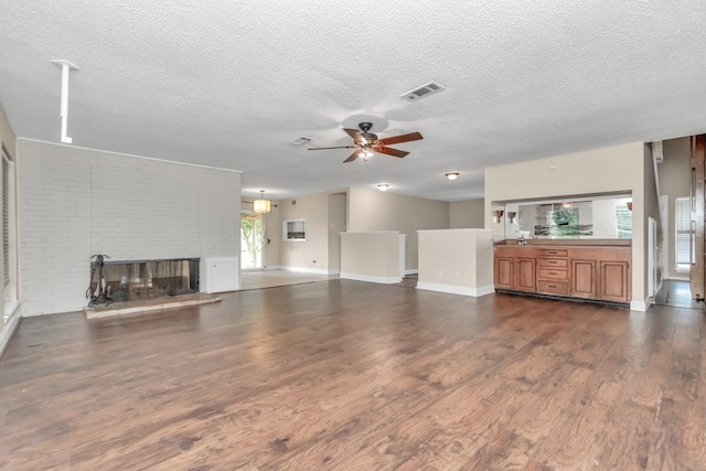 unfurnished living room with dark hardwood / wood-style flooring, a fireplace, a wealth of natural light, and ceiling fan