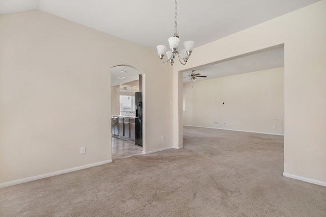 carpeted empty room with ceiling fan with notable chandelier and vaulted ceiling