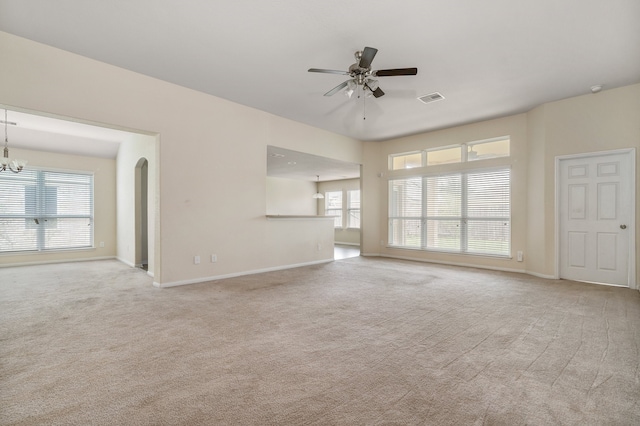 unfurnished living room with carpet flooring and ceiling fan with notable chandelier