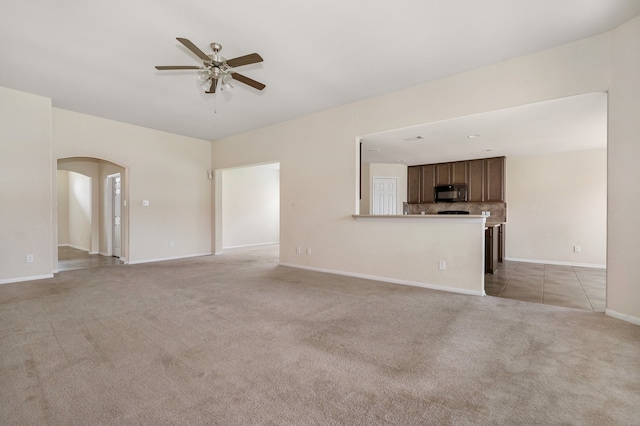 unfurnished living room featuring light colored carpet and ceiling fan