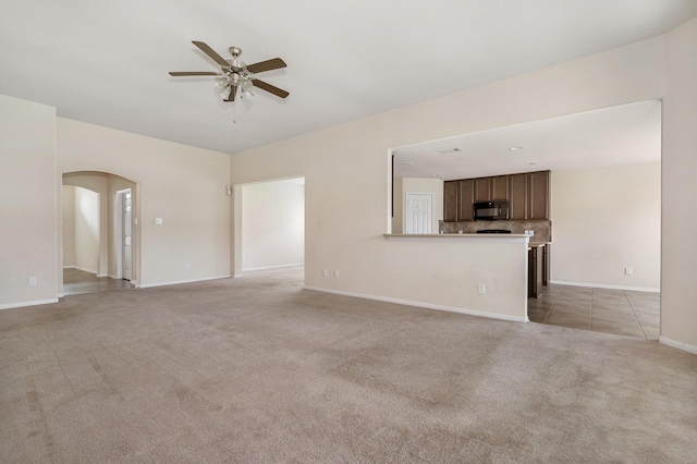 3019 Fern Brook Ln, Rosenberg, TX 77471 - unfurnished living room with arched walkways, ceiling fan, light colored carpet, and baseboards