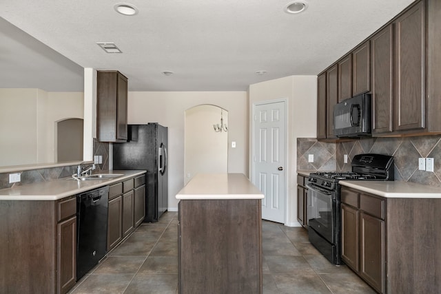 kitchen featuring black appliances, dark tile patterned floors, decorative backsplash, and dark brown cabinetry