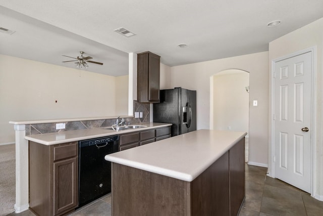 3019 Fern Brook Ln, Rosenberg, TX 77471 - kitchen with black appliances, a sink, arched walkways, ceiling fan, and a kitchen island