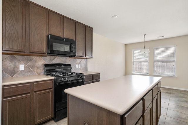 kitchen featuring light tile patterned floors, a center island, black appliances, hanging light fixtures, and decorative backsplash