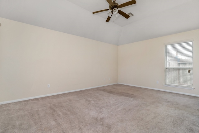 carpeted spare room featuring ceiling fan and vaulted ceiling