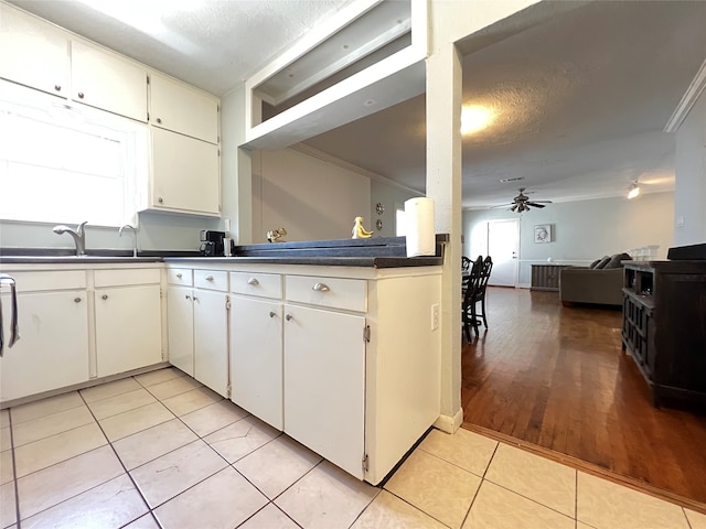 kitchen featuring white cabinets, sink, light tile patterned floors, crown molding, and ceiling fan