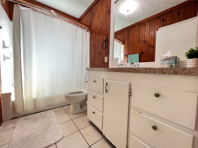 bathroom with a textured ceiling, wood walls, toilet, vanity, and tile patterned floors