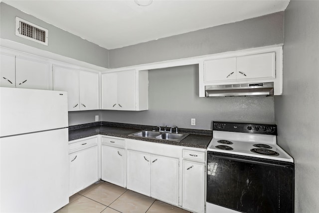 kitchen with white appliances, wall chimney range hood, sink, light tile patterned floors, and white cabinetry