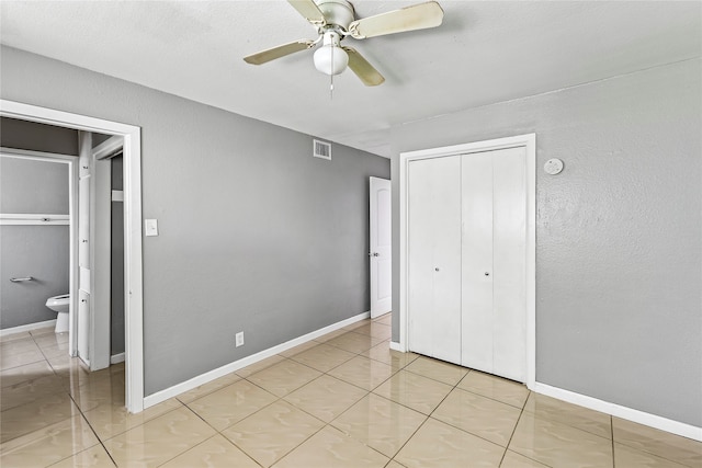 unfurnished bedroom featuring a closet, light tile patterned floors, and ceiling fan