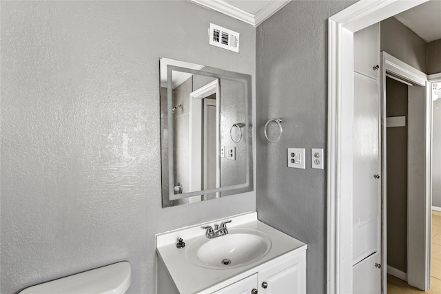 bathroom with crown molding, toilet, and vanity