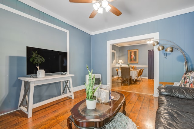 living room featuring ceiling fan, wood-type flooring, and ornamental molding