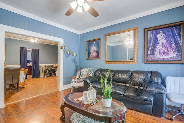 living room featuring wood-type flooring, ceiling fan, and crown molding