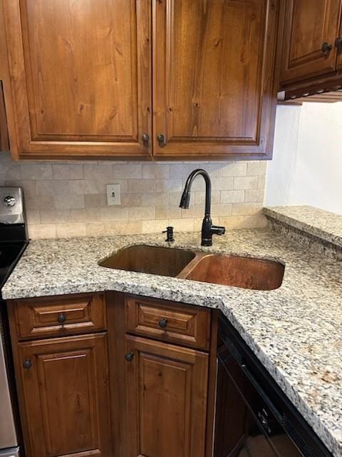 kitchen featuring stainless steel electric range, light stone countertops, and sink