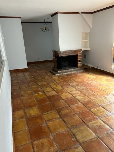 unfurnished living room with a brick fireplace, crown molding, and a notable chandelier