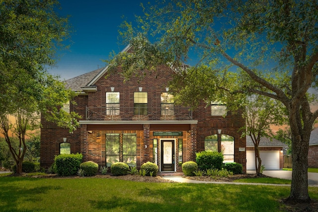 view of front facade featuring driveway, brick siding, a lawn, and a balcony