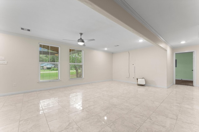 spare room featuring visible vents, crown molding, baseboards, and ceiling fan