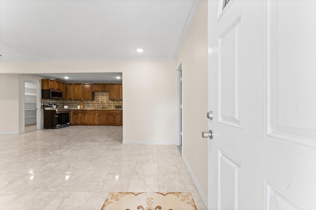 kitchen featuring stainless steel microwave, backsplash, electric range oven, brown cabinetry, and baseboards