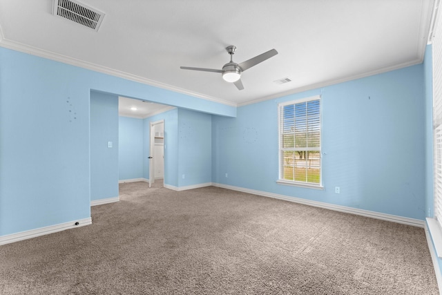 carpeted empty room with ornamental molding, visible vents, baseboards, and a ceiling fan