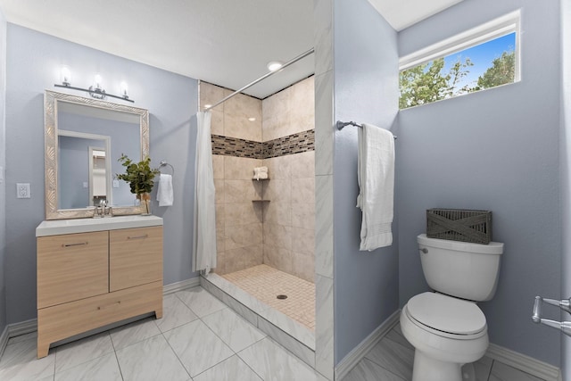 bathroom featuring toilet, baseboards, a tile shower, and vanity