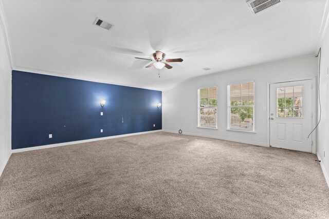 carpeted spare room featuring lofted ceiling, ornamental molding, and ceiling fan