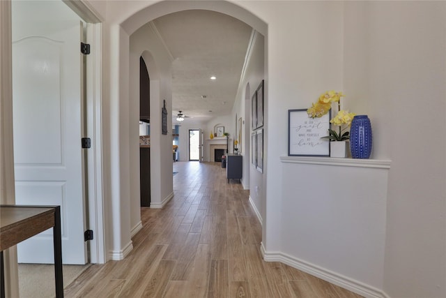 corridor with crown molding and light wood-type flooring