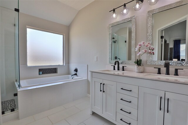 bathroom featuring independent shower and bath, vaulted ceiling, tile patterned floors, and vanity