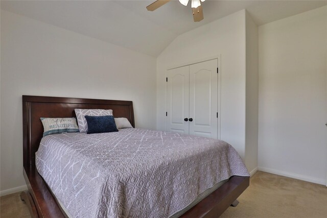 carpeted bedroom featuring ceiling fan, a closet, and vaulted ceiling