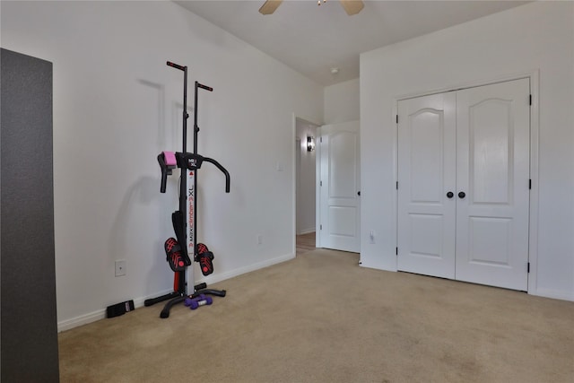 workout area featuring light carpet and ceiling fan