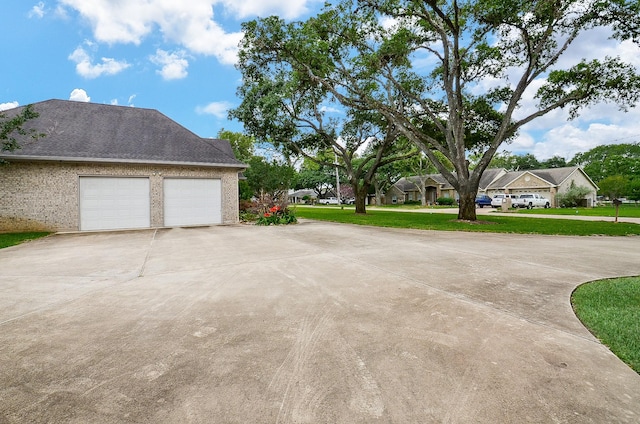 view of yard featuring an attached garage and concrete driveway