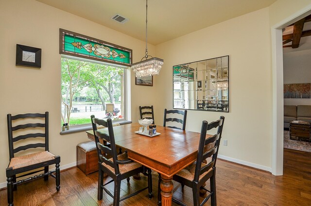 dining room with dark hardwood / wood-style flooring and a chandelier