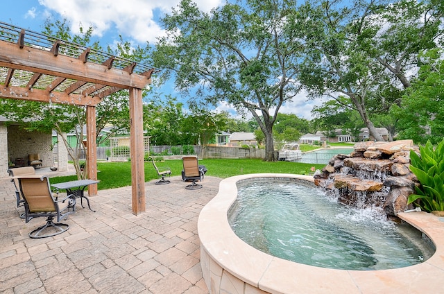 view of pool featuring pool water feature, a pergola, a patio area, and a lawn