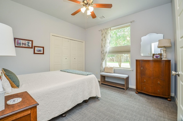 carpeted bedroom with a ceiling fan, baseboards, visible vents, and a closet