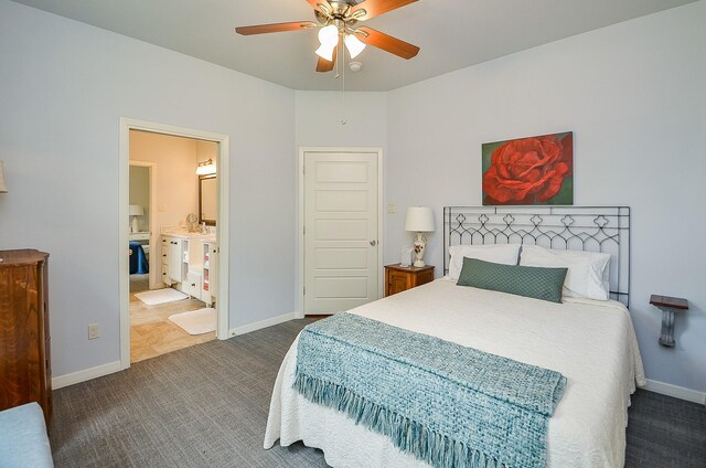 bedroom with connected bathroom, dark carpet, and ceiling fan