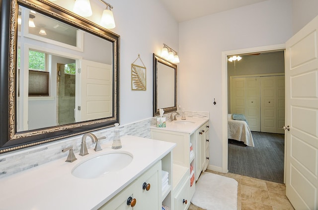 bathroom featuring a shower, two vanities, and a sink