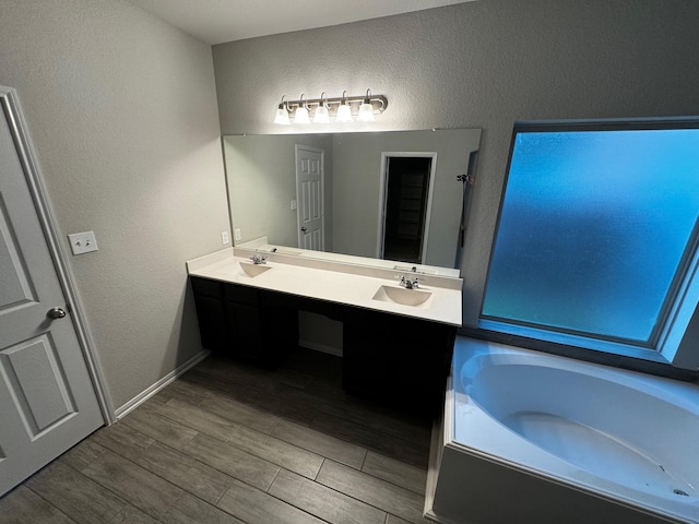 bathroom with wood-type flooring, a bathtub, and double vanity