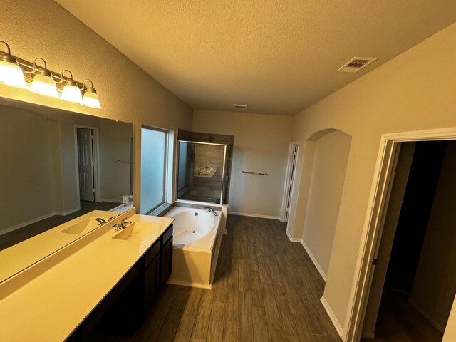 bathroom featuring vanity, shower with separate bathtub, hardwood / wood-style floors, and a textured ceiling