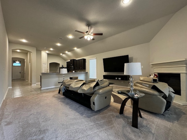 living room featuring light carpet, ceiling fan, and vaulted ceiling