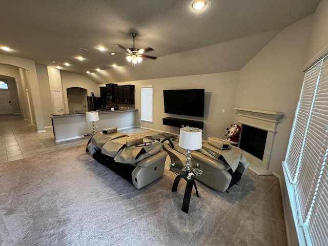 living room featuring light carpet, lofted ceiling, and ceiling fan