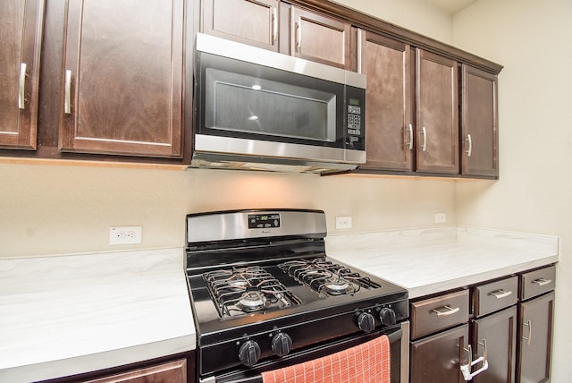 kitchen with black range with gas stovetop and dark brown cabinetry