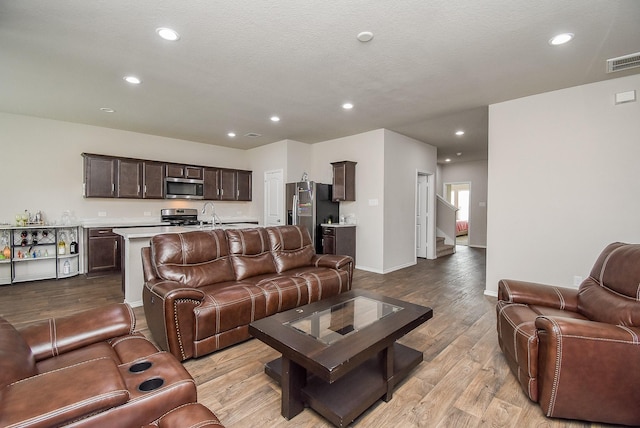 living room featuring light hardwood / wood-style floors and sink