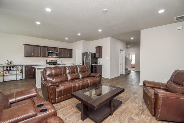 living room featuring light hardwood / wood-style floors and sink