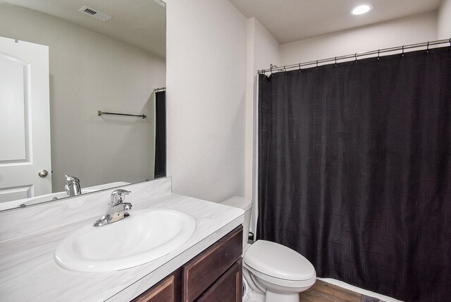 bathroom featuring wood-type flooring, vanity, and toilet