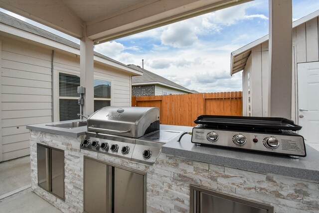 view of patio / terrace featuring a grill, sink, and an outdoor kitchen