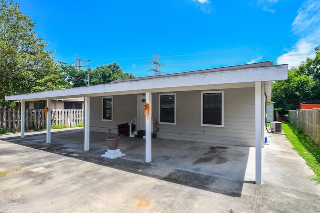 view of front of property featuring central AC and a carport