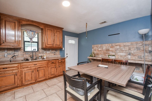 kitchen featuring light tile patterned floors, tasteful backsplash, and sink