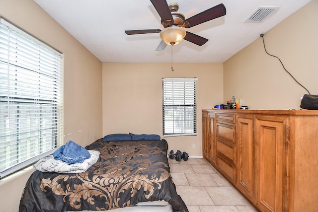 tiled bedroom with multiple windows and ceiling fan