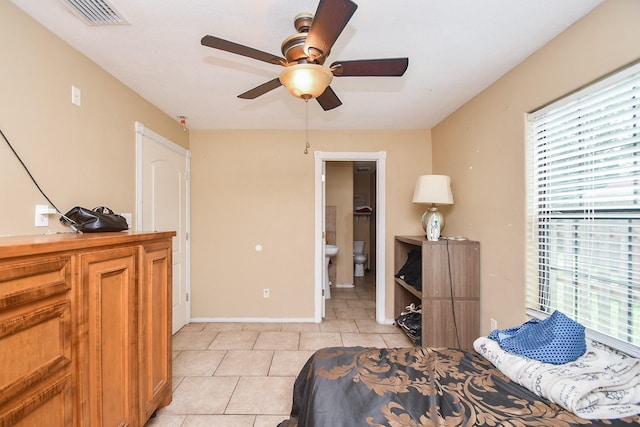 tiled bedroom featuring ceiling fan and connected bathroom